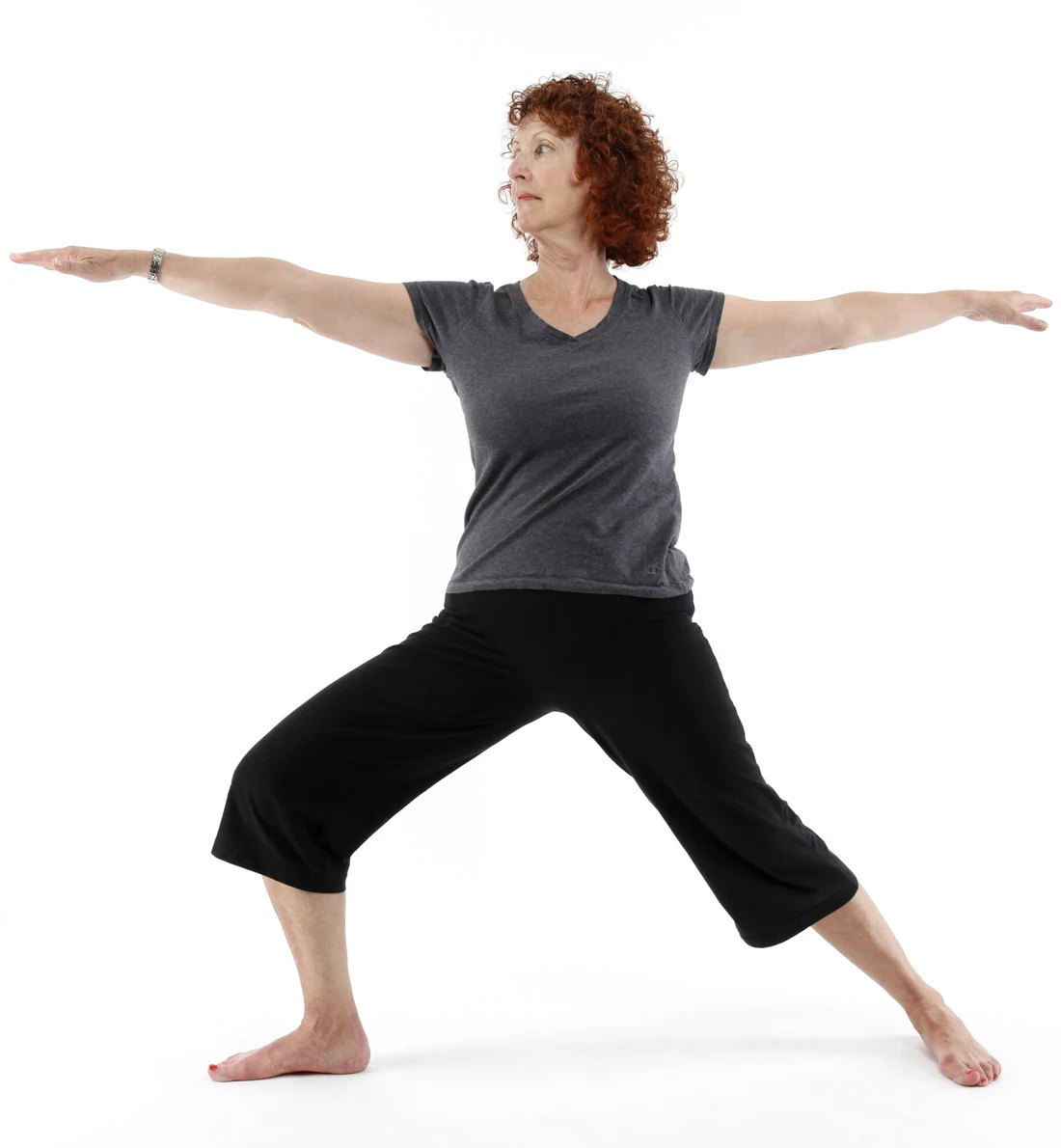 A practitioner holding Warrior II, arms level with the shoulders